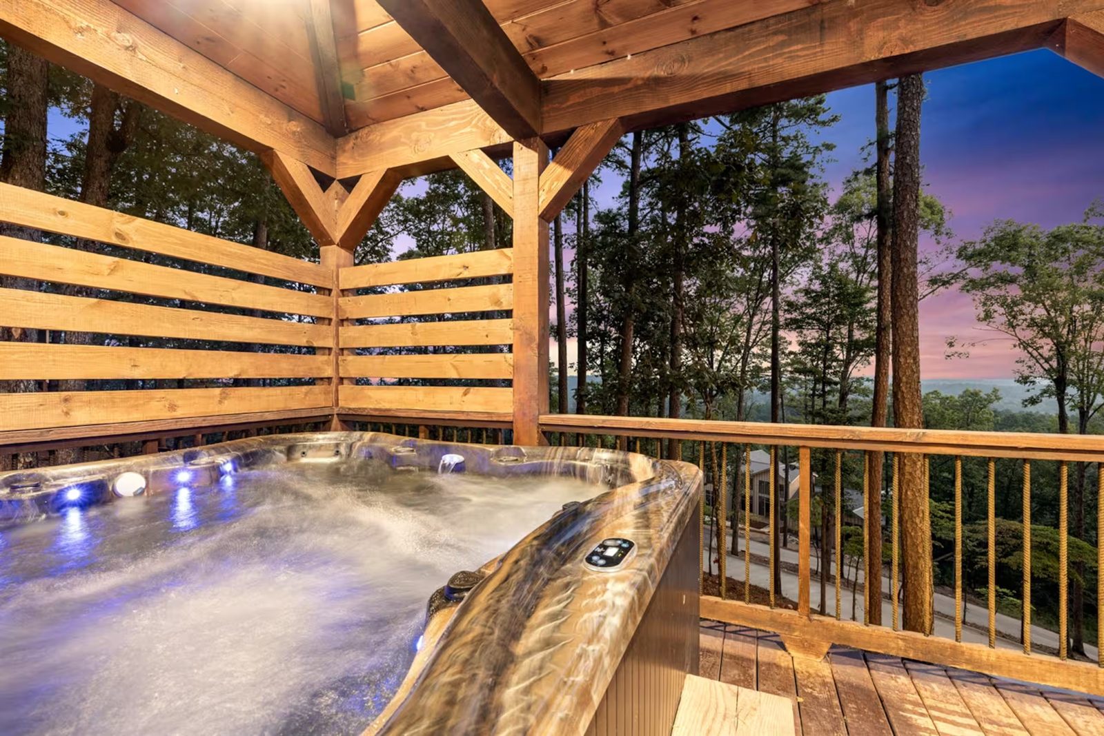 Private hot tub at dusk, on a screened porch above the tree line.